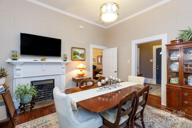 dining area with hardwood / wood-style floors and ornamental molding