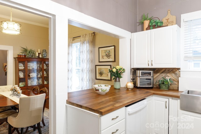 kitchen with dishwasher, butcher block countertops, crown molding, decorative light fixtures, and white cabinets