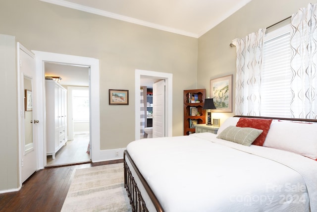 bedroom featuring ensuite bathroom, hardwood / wood-style floors, and ornamental molding