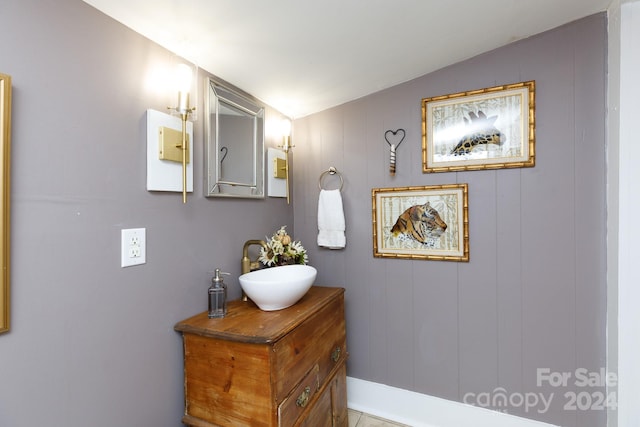 bathroom featuring tile patterned flooring, vanity, and vaulted ceiling