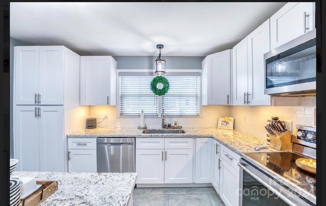 kitchen with hanging light fixtures, white cabinetry, sink, and appliances with stainless steel finishes