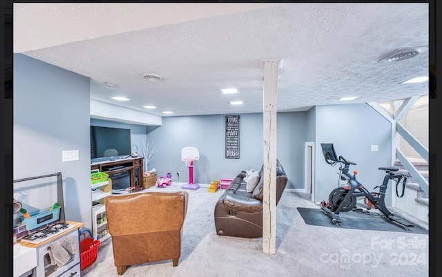 exercise area featuring light colored carpet and a textured ceiling