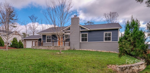 back of property featuring a garage and a lawn