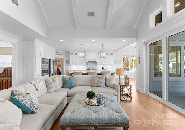 living room featuring light hardwood / wood-style floors and beam ceiling