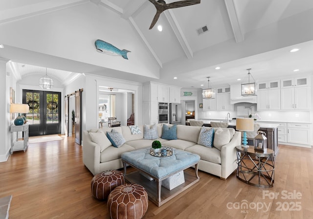 living room featuring light hardwood / wood-style flooring, ceiling fan, french doors, high vaulted ceiling, and beamed ceiling