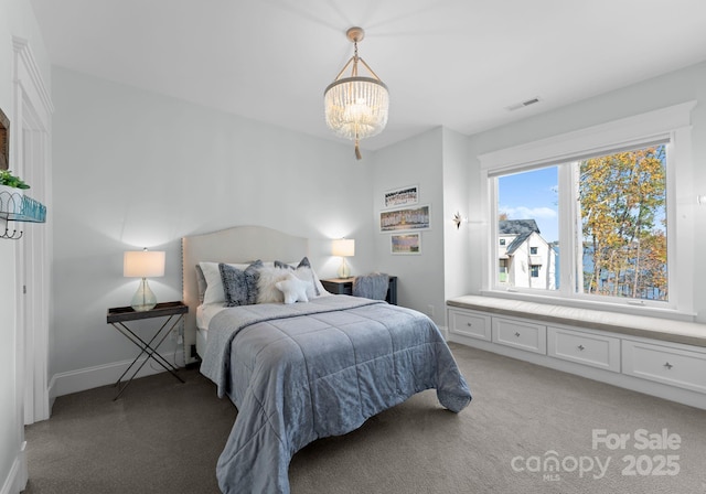 carpeted bedroom featuring a notable chandelier