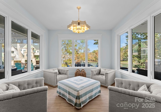 sunroom / solarium featuring plenty of natural light and an inviting chandelier