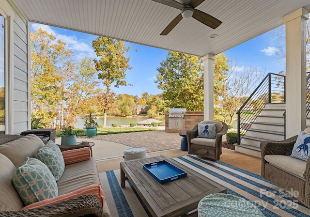 view of patio with an outdoor living space, ceiling fan, area for grilling, a water view, and a grill