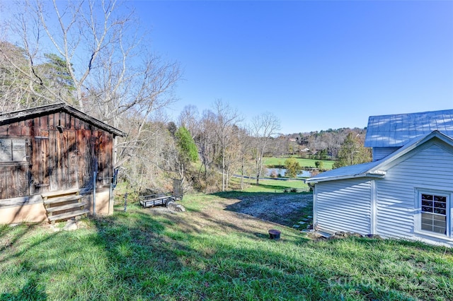 view of yard with a storage unit and a water view