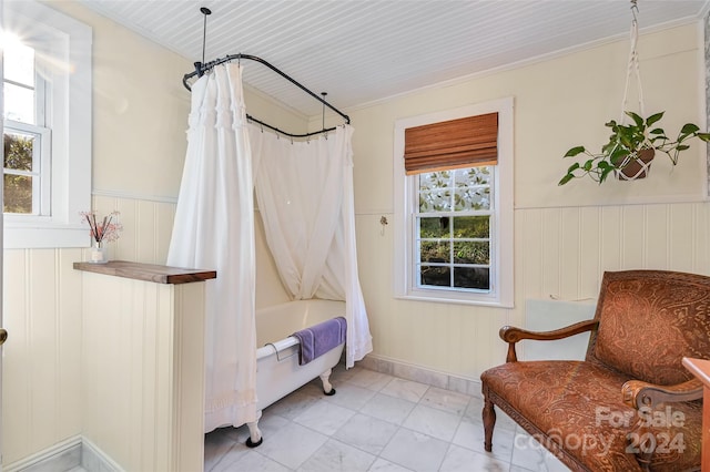 bathroom with shower / tub combo, a wealth of natural light, and ornamental molding