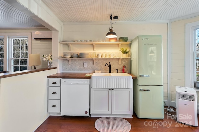 kitchen with dark wood-type flooring, hanging light fixtures, white appliances, and sink