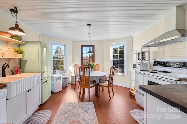 dining room featuring crown molding, plenty of natural light, and hardwood / wood-style floors