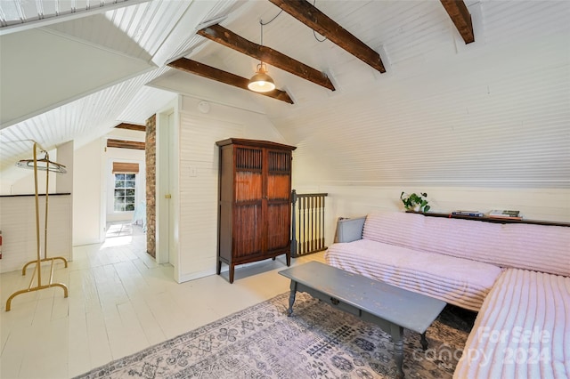 sitting room featuring vaulted ceiling with beams and wooden walls