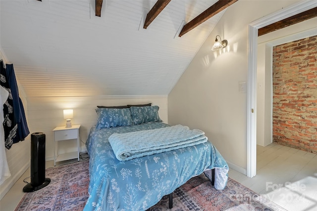 bedroom with vaulted ceiling with beams, ceiling fan, and brick wall