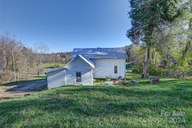 rear view of house featuring a lawn