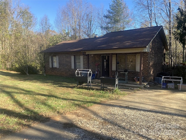 ranch-style home with a front lawn and covered porch