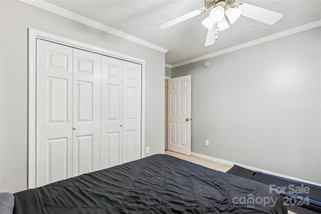 unfurnished bedroom featuring ornamental molding, a textured ceiling, ceiling fan, carpet floors, and a closet