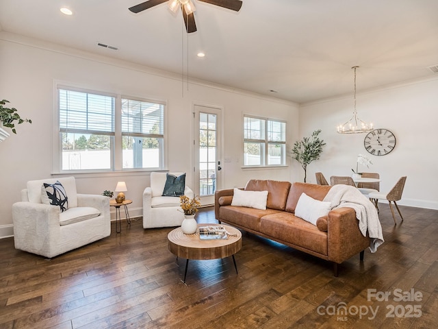 living room with dark hardwood / wood-style flooring, ceiling fan with notable chandelier, and ornamental molding