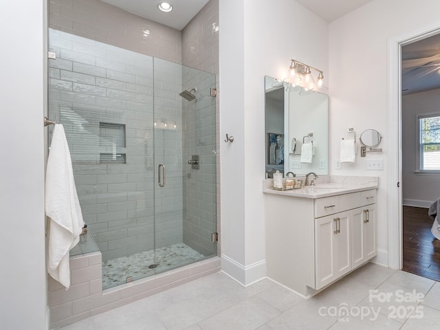 bathroom featuring tile patterned flooring, vanity, and a shower with door