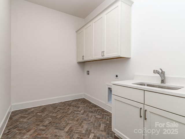 clothes washing area featuring hookup for an electric dryer, hookup for a washing machine, cabinets, and sink