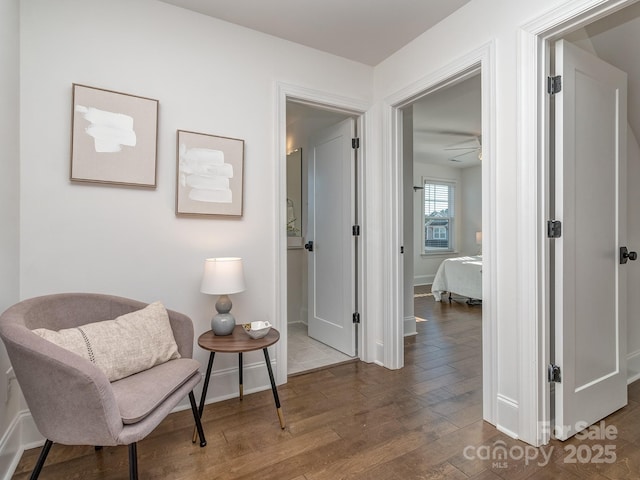 sitting room with dark hardwood / wood-style flooring and ceiling fan