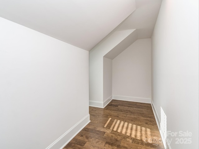 additional living space featuring dark hardwood / wood-style flooring and vaulted ceiling