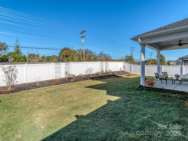 view of yard with ceiling fan and a patio