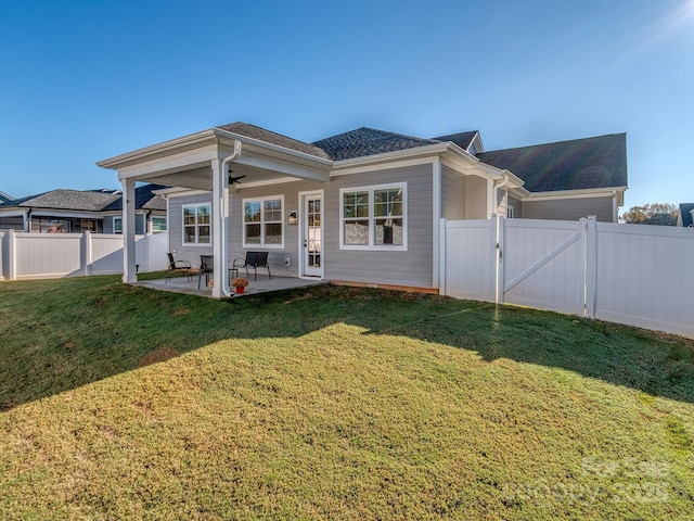 rear view of house with a patio and a lawn