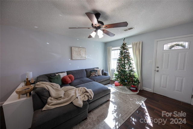 living room featuring a textured ceiling, dark hardwood / wood-style flooring, and ceiling fan