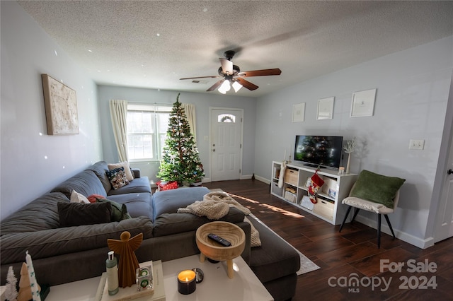 living room with a textured ceiling, dark hardwood / wood-style flooring, and ceiling fan