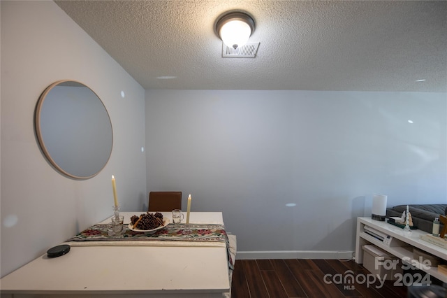 interior space with dark wood-type flooring and a textured ceiling