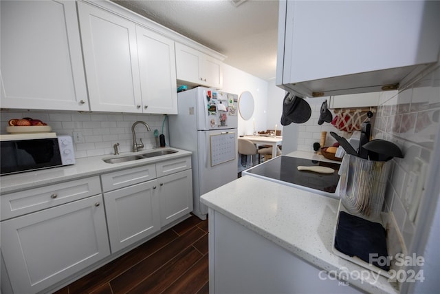 kitchen with white cabinetry, sink, tasteful backsplash, dark hardwood / wood-style flooring, and white fridge