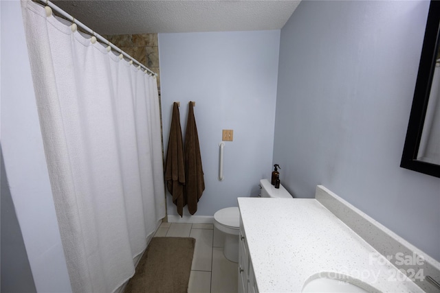 bathroom featuring tile patterned floors, vanity, toilet, and a textured ceiling