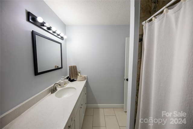 bathroom featuring tile patterned flooring, a shower with curtain, a textured ceiling, and vanity