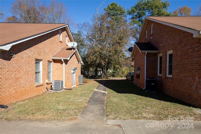 view of side of home featuring a lawn and central air condition unit