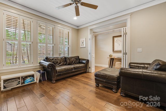 living room with a wealth of natural light, hardwood / wood-style floors, ceiling fan, and ornamental molding