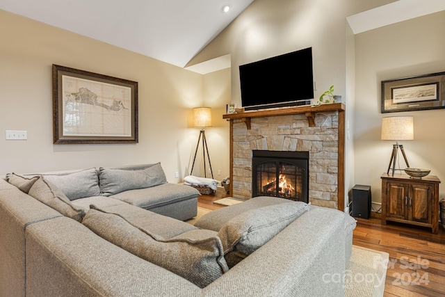 living room with a fireplace, wood-type flooring, and lofted ceiling