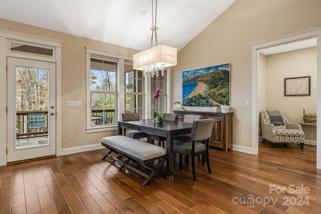 dining room featuring dark hardwood / wood-style flooring, lofted ceiling, and an inviting chandelier