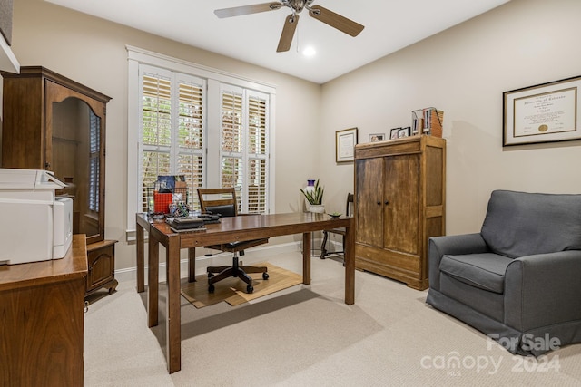 carpeted home office featuring ceiling fan