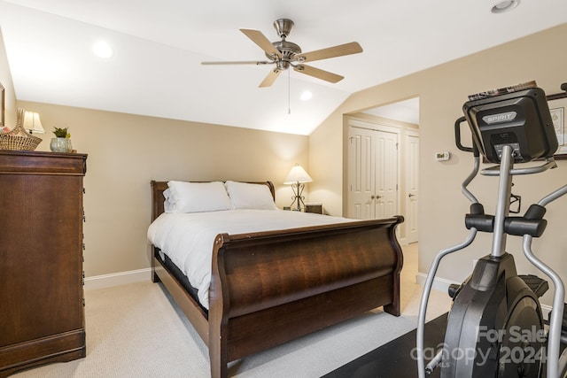 carpeted bedroom with ceiling fan, a closet, and vaulted ceiling