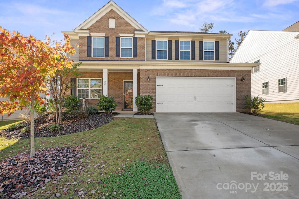 view of front of house with a garage, a front yard, and covered porch