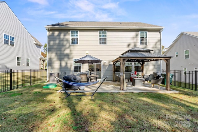 rear view of property featuring a gazebo, a patio, and a lawn