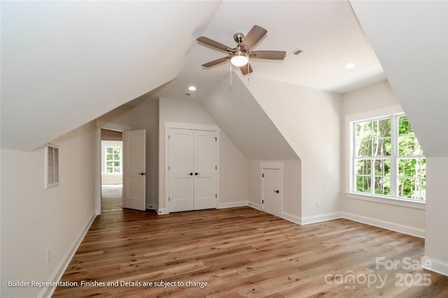 bonus room featuring ceiling fan, a wealth of natural light, wood finished floors, and visible vents