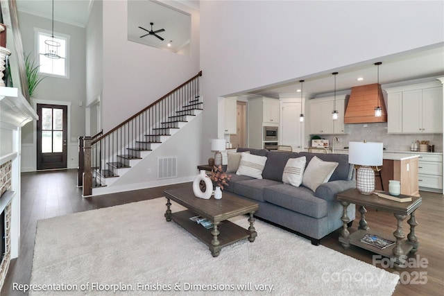 4271 Candlewood Dr, Sherrills Ford, NC 28673 - living area featuring dark wood finished floors, a high ceiling, stairs, a fireplace, and crown molding