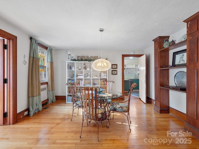 dining area featuring light hardwood / wood-style floors and a textured ceiling