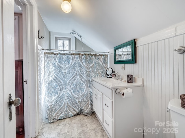 bathroom featuring vanity, curtained shower, vaulted ceiling, and toilet