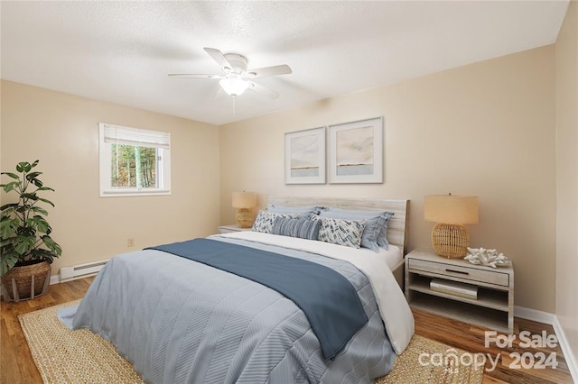 bedroom with ceiling fan, wood-type flooring, and a baseboard radiator