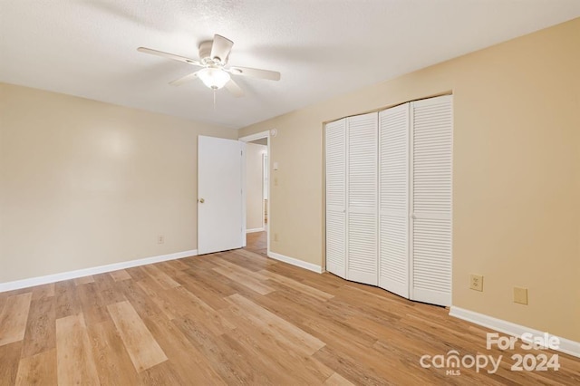 unfurnished bedroom with a closet, light hardwood / wood-style flooring, and ceiling fan