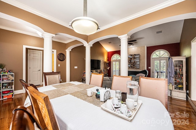 dining space featuring dark hardwood / wood-style flooring, crown molding, lofted ceiling, and ornate columns