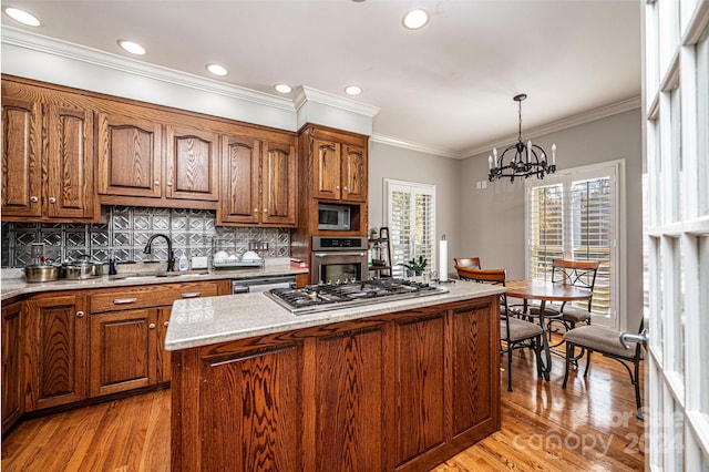 kitchen featuring sink, hanging light fixtures, plenty of natural light, and appliances with stainless steel finishes